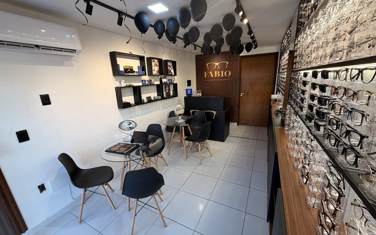Visão geral do interior da Fábio Ótica, com expositores e ambiente acolhedor